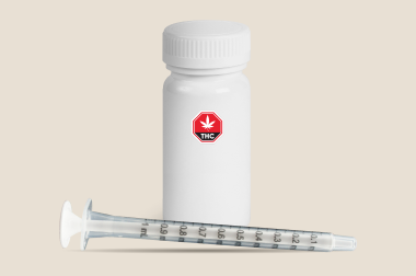 Bouteille d’huile comestible et seringue de dosage graduée Bouteille blanche d’huile comestible avec symbole THC, accompagnée d’une seringue de dosage graduée, sur fond beige.