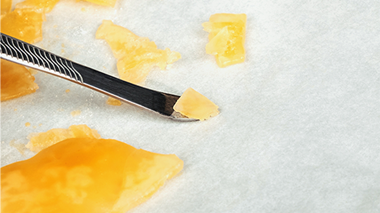 Illustration d’une main tenant une vapoteuse de cannabis à filetage 510 avec aérosol.