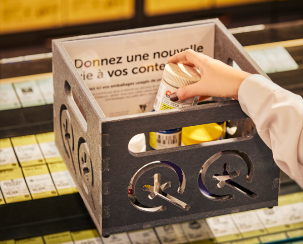 Client déposant un contenant de cannabis usagé dans une boîte de recyclage à la SQDC pour le programme de récupération des emballages